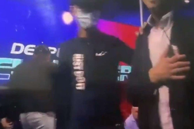 ...e coloca uma banana de dinamite no bolso da camisa do jornalista, durante a transmissão ao vivo