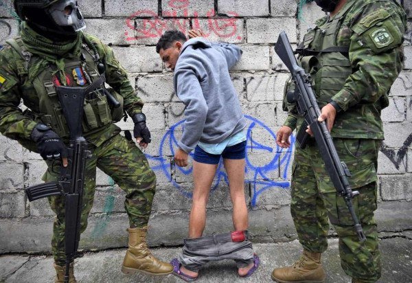 Soldados revistam suspeito durante patrulha no bairro Lucha de los Pobres, na região sul de Quito 