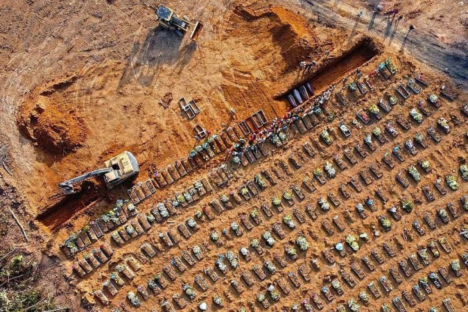  Aerial view of coffins being buried at an area where new graves have been dug at the Parque Taruma cemetery, during the COVID-19 coronavirus pandemic in Manaus, Amazonas state, Brazil, on April 21, 2020. - Graves are being dug at a new area of the cemetery for suspected and confirmed victims of the COVID-19 coronavirus pandemic. (Photo by MICHAEL DANTAS / AFP)
      Caption  -  (crédito:  AFP)