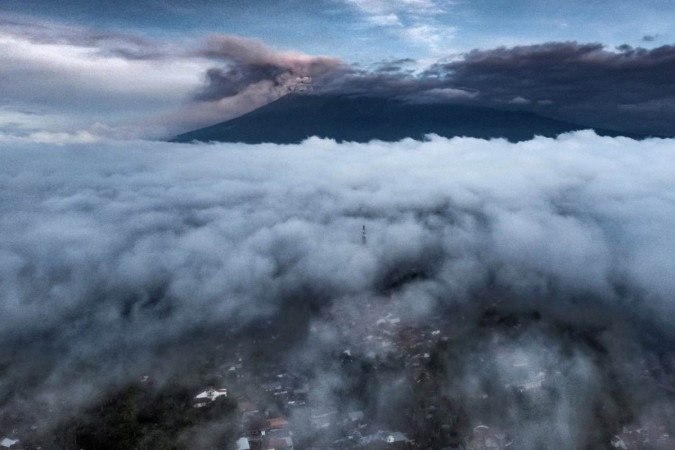 Vista aérea mostra o vulcão Monte Marapi emitindo cinzas vulcânicas durante uma erupção vista de Tanah Datar, no oeste de Sumatra. -  (crédito: ADI PRIMA / AFP)