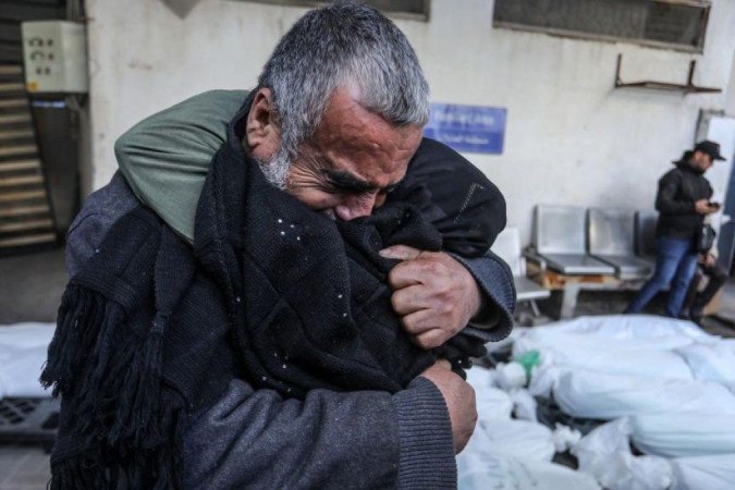 Um homem sentado em frente aos escombros de uma casa em Rafah, no sul da Faixa de Gaza -  (crédito: Getty Images)