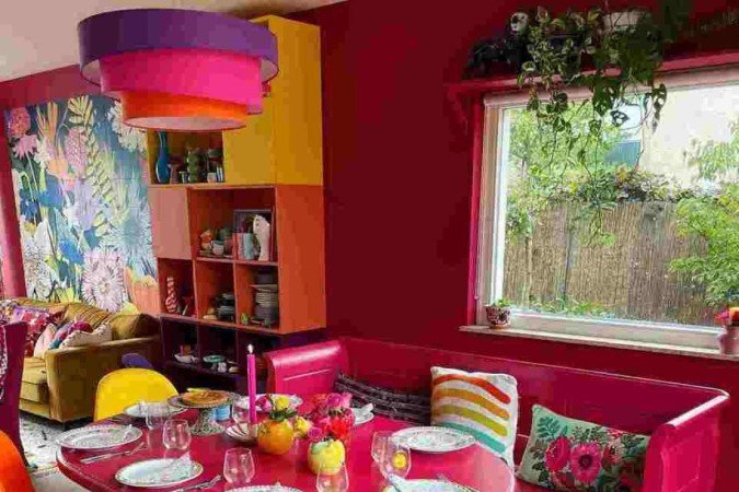 As cores extravagantes e o design divertido das cadeiras e do lustre são os elementos que mais chamam a atenção nesta sala de jantar