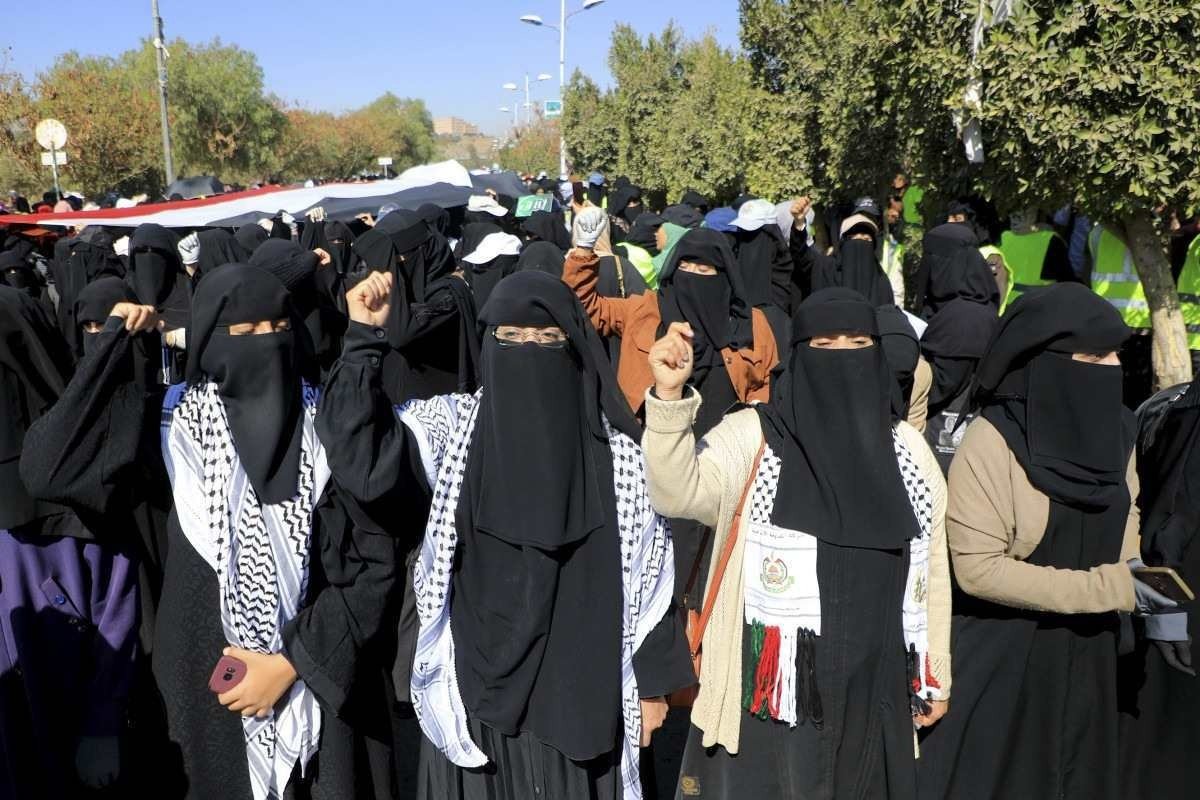 Mulheres iemenitas vestindo o keffiyeh, traje tradicional palestino, protestam contra Israel e EUA em Sanaa