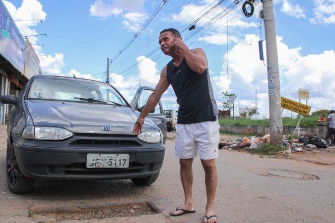  19/01/2024 Crédito: Kayo Magalhães/CB/D.A Press. Brasil. Brasília - DF. Cidades. Buracos no DF em períodos de chuva. Domingos Ribeiro, 59, reclama que precisa fazer balanceamento frequente no carro devido aos buracos na Estrutural. 