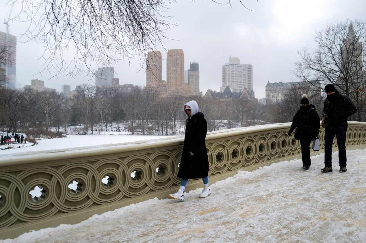 As pessoas caminham pelo Central Park de Nova York enquanto a neve cai durante uma tempestade de inverno em 19 de janeiro de 2024