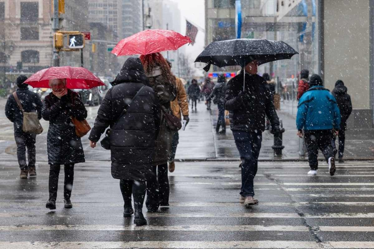 Pessoas caminham pela neve fraca em Manhattan enquanto Nova York recebe sua segunda nevasca em uma semana em 19 de janeiro de 2024 na cidade de Nova York