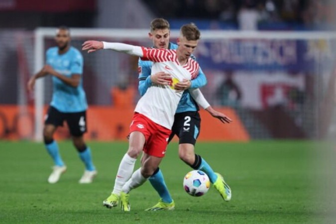 Dani Olmo (de branco) recebe a marcação do croata Stanisic, do Leverkusen   -  (crédito: Foto:  Ronny Hartmann/ AFP via Getty Images)