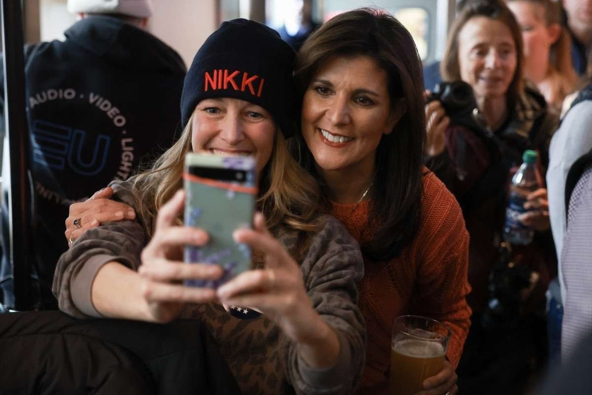Nikki Haley (D), ex-embaixadora dos EUA na ONU e candidata republicana, faz selfie com  eleitora em Concord, New Hampshire