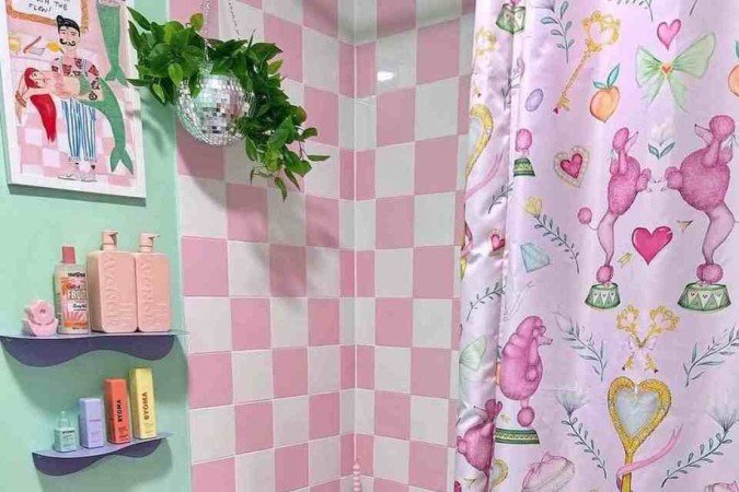 O formato curioso da mesinha e a mistura de estampas na cortina, tapete, piso e azulejos trazem um ar divertido para o banheiro