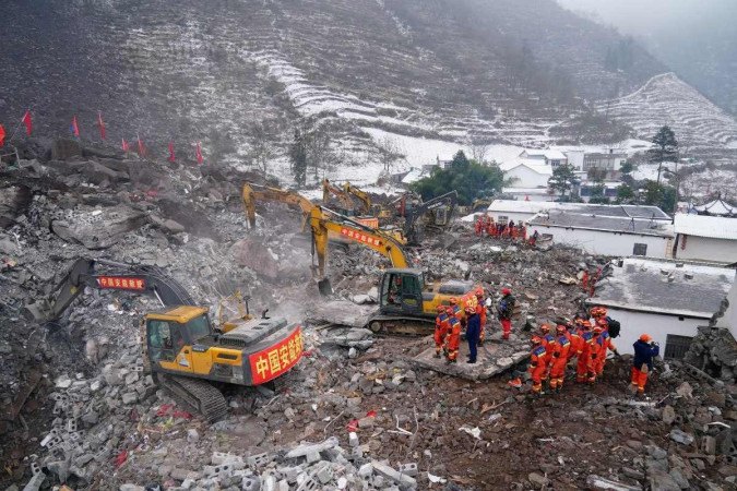 Equipes de resgate procuram vítimas desaparecidas em um local de deslizamento de terra, um dia depois que um deslizamento atingiu a vila de Liangshui em Zhaotong, na província de Yunnan -  (crédito: STR / CNS / AFP)