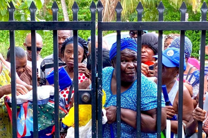 Mulheres aguardam sob o sol de Miami em fila para doação de comida em Little Haiti -  (crédito: BBC)