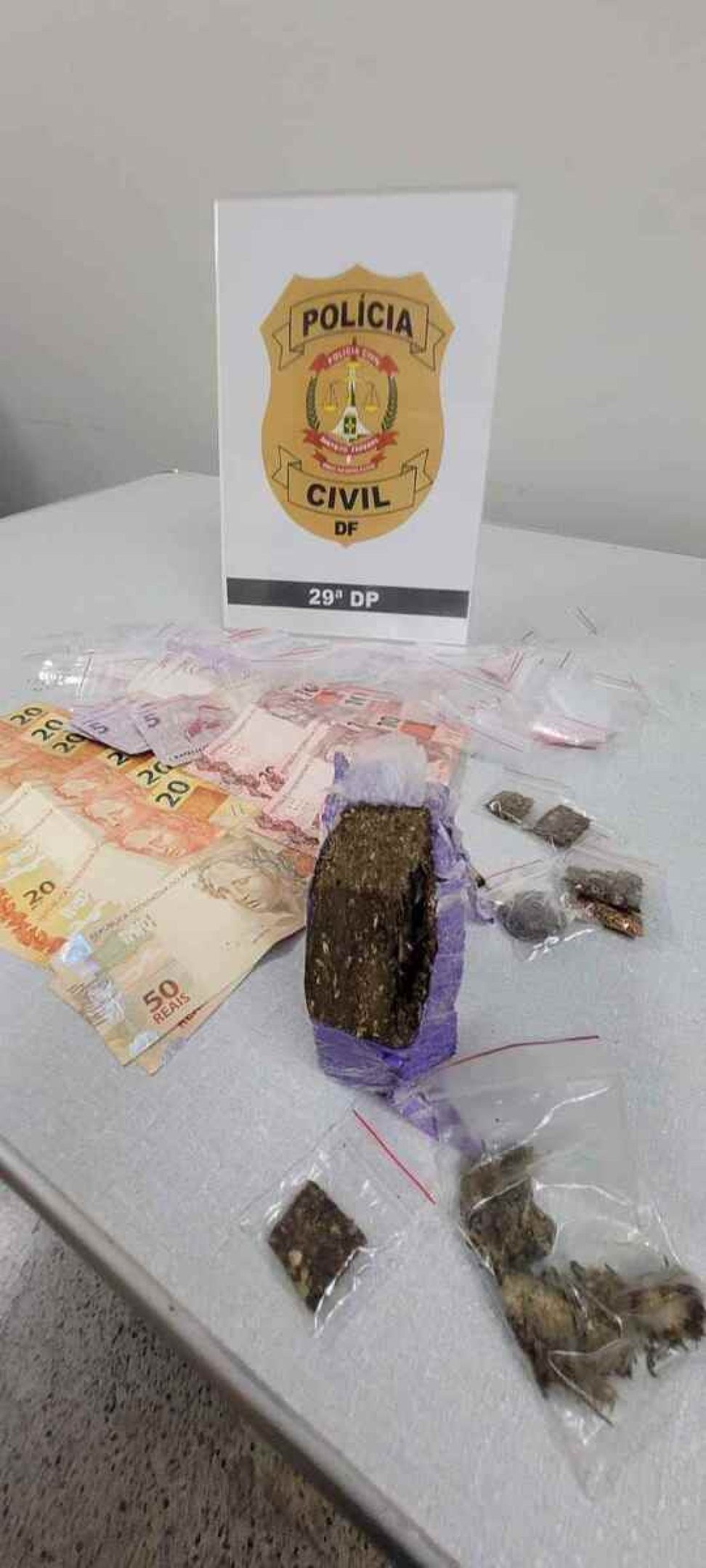 Foram apreendidos sacos de maconha para consumo, um tijolo do entorpecente e dinheiro. 