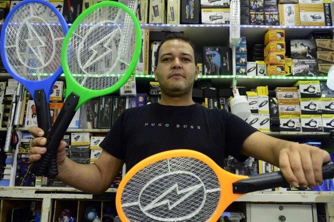 O vendedor Elias Ferreira mostra raquetes de matar mosquito. Vendas dispararam