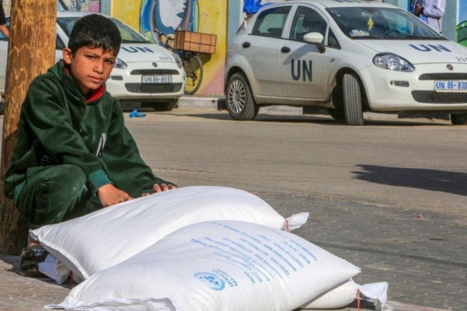 Criança ao lado de mantimentos dados pela agência da ONU em Gaza -  (crédito: Getty Images)