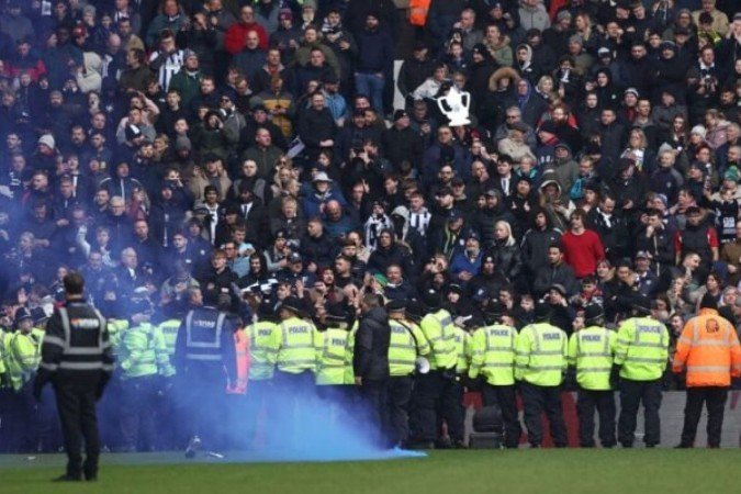 Policias e seguranças tentam conter o distúrbio no estádio de West Brom  -  (crédito: Foto: Darren Staples AFP via Getty Images)
