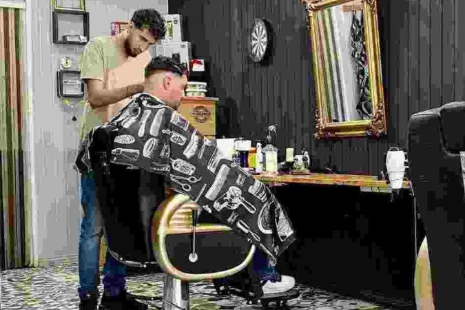 Leonardo Valentim de Souza, sócio da Rota 351 Barber Shop, corta o cabelo de um português