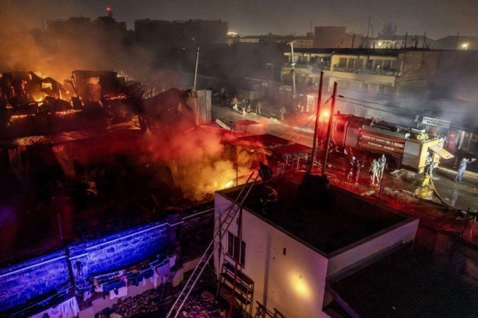 Bombeiros combatem um incêndio após uma série de explosões na área de Embakasi, em Nairóbi, no Quênia, em 2 de fevereiro de 2024.    -  (crédito: Luis TATO / AFP)