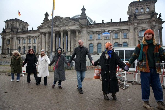 Manifestantes formam uma corrente humana em torno do edifício do Reichstag  sob o lema 'Nós somos o firewall'. -  (crédito:  Adam Berry/AFP)