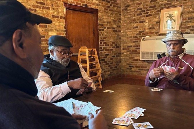 Tyrone Dash (esq.) joga cartas com amigos no condado de Orangeburg, na Carolina do Sul -  (crédito: BBC)