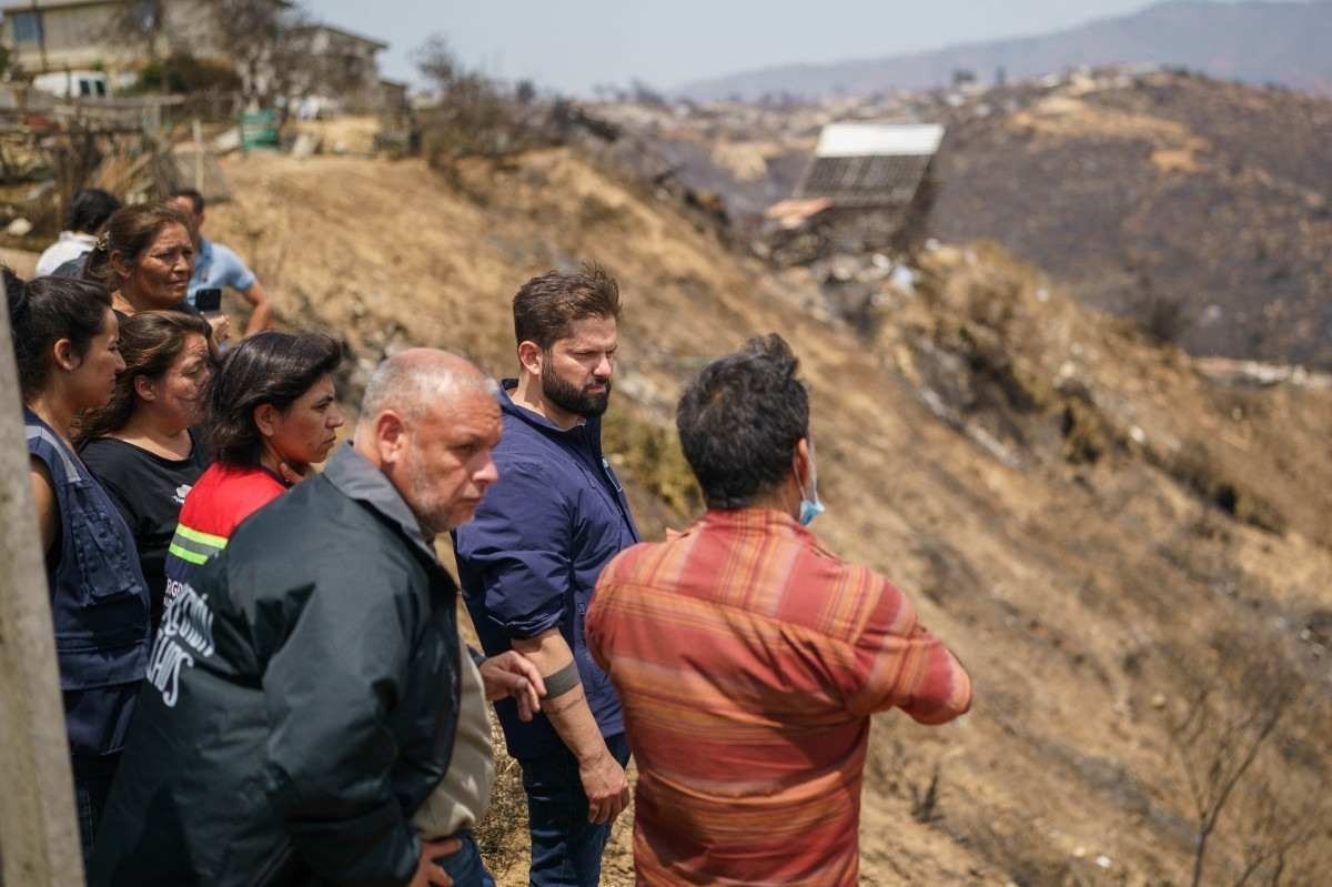 O presidente Gabriel Boric (C) conversa com moradores de Quilpué, comuna de Valparaíso afetada pela catástrofe 