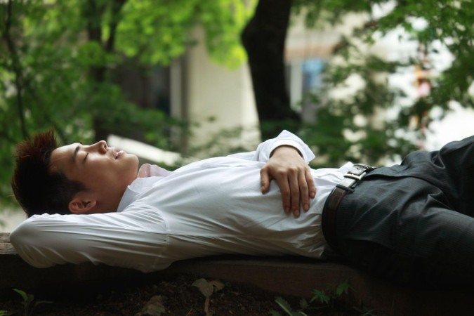 Trabalhadores japoneses cochilam em bancos de parque. É o hábito conhecido como 'hirune', ou 'soneca da tarde' -  (crédito: Getty Images)