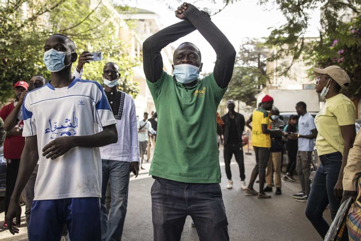Um manifestante gesticula para a polícia do lado de fora da Assembleia Geral em Plateau, Dakar 