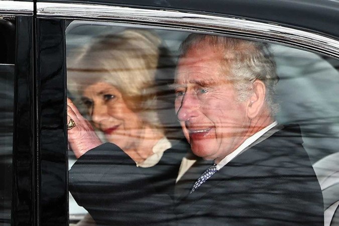 Rei Charles e Camilla acenam ao saírem de carro de Clarence House, em Londres  -  (crédito: Henry Nicholls / AFP)