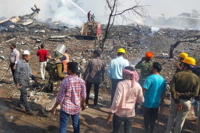 Equipes de resgate e residentes locais se reúnem perto de uma fábrica de fogos de artifício após uma explosão no distrito de Harda, no estado indiano de Madhya -  (crédito: AFP)