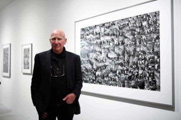  TOPSHOT - Brazilian photographer Sebastiao Salgado stands in front of his work at the Bene Taschen gallery at his exhibition Gold in Cologne on February 6, 2020. RESTRICTED TO EDITORIAL USE - MANDATORY MENTION OF THE ARTIST UPON PUBLICATION - TO ILLUSTRATE THE EVENT AS SPECIFIED IN THE CAPTION / AFP / INA FASSBENDER / RESTRICTED TO EDITORIAL USE - MANDATORY MENTION OF THE ARTIST UPON PUBLICATION - TO ILLUSTRATE THE EVENT AS SPECIFIED IN THE CAPTION -  (crédito:  INA FASSBENDER)