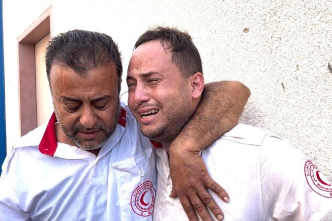 Mahmoud (à direita) foi consolado por um colega após descobrir que seu pai havia sido morto -  (crédito: Feras Al Ajrami)
