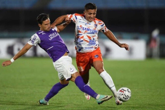 Nicolas Rodríguez, do Defensor (à esquerda) divide a bola com  Cobos, do Puerto Cabello -  (crédito: Foto: Dante Fernández / AFP via Getty Images)