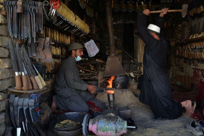  Afghan blacksmiths hammer hot iron on an anvil at a workshop in Kandahar on February 15, 2024. (Photo by Sanaullah SEIAM / AFP)
      Caption  -  (crédito: SANAULLAH SEIAM / AFP)