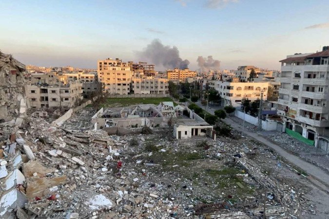  A picture taken in Gaza City shows debris from destroyed buildings and smoke billowing in the background during Israeli bombardment on February 20, 2024, amid continuing battles between Israel and the Palestinian militant group Hamas. (Photo by AFP)
       -  (crédito:  AFP)