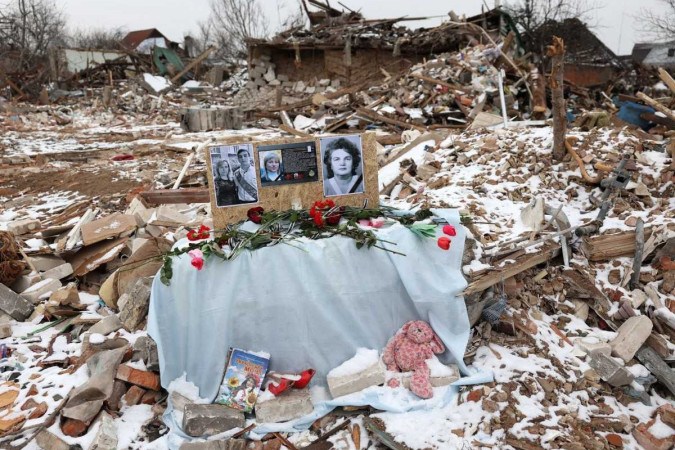 Retratos de vítimas de bombardeio russo durante cerimônia fúnebre em destroços de uma casa da família em Kramatorsk, em Donetsk  -  (crédito:  AFP)