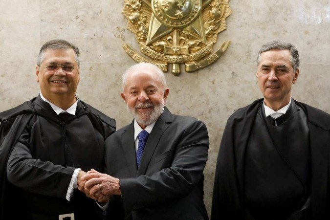  Supreme Court minister Flavio Dino (L) shakes hands with Brazilian President Luiz Inácio Lula da Silva (C), next to the president of the Brazilian Supreme Court Roberto Barroso during his inauguration as new minister of the Federal Supreme Court (STF), Brasília, on February 22, 2024. (Photo by Sergio Lima / AFP)
      