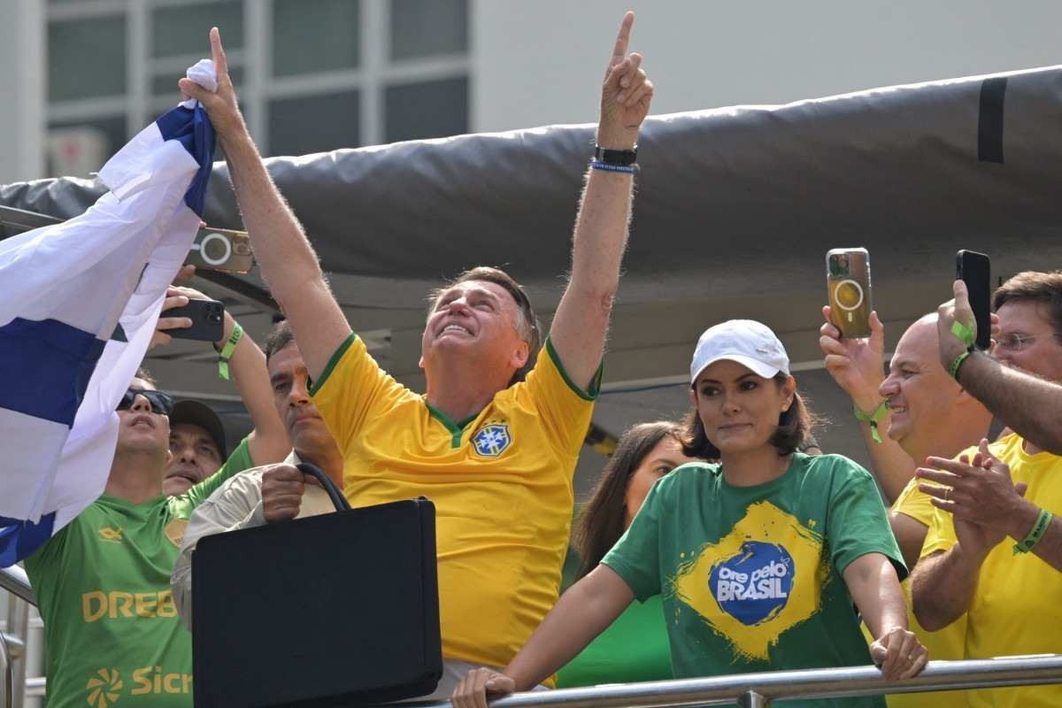  Former Brazilian President Jair Bolsonaro (C-L)) gestures next to his wife Michelle Bolsonaro (C-R) during a rally in Sao Paulo, Brazil, on February 25, 2024, to reject claims he plotted a coup with allies to remain in power after his failed 2022 reelection bid. Investigators say the far-right ex-army captain led a plot to falsely discredit the Brazilian election system and prevent the winner of the vote, leftist President Luiz Inacio Lula da Silva, from taking power. A week after Lula took office on January 1, 2023, thousands of Bolsonaro supporters stormed the presidential palace, Congress and Supreme Court, urging the military to intervene to overturn what they called a stolen election. (Photo by NELSON ALMEIDA / AFP)       