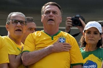 O ex-presidente brasileiro Jair Bolsonaro (C) canta o hino nacional ao lado de sua esposa Michelle Bolsonaro (R) e do pastor Silas Malafaia (L) durante um comício em São Paulo -  (crédito: NELSON ALMEIDA / AFP)