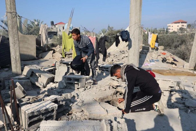 Palestinos revistam os escombros de casa destruída em um ataque aéreo israelense noturno no leste de Khan Yunis, no sul da Faixa de Gaza       -  (crédito: SAID KHATIB / AFP)