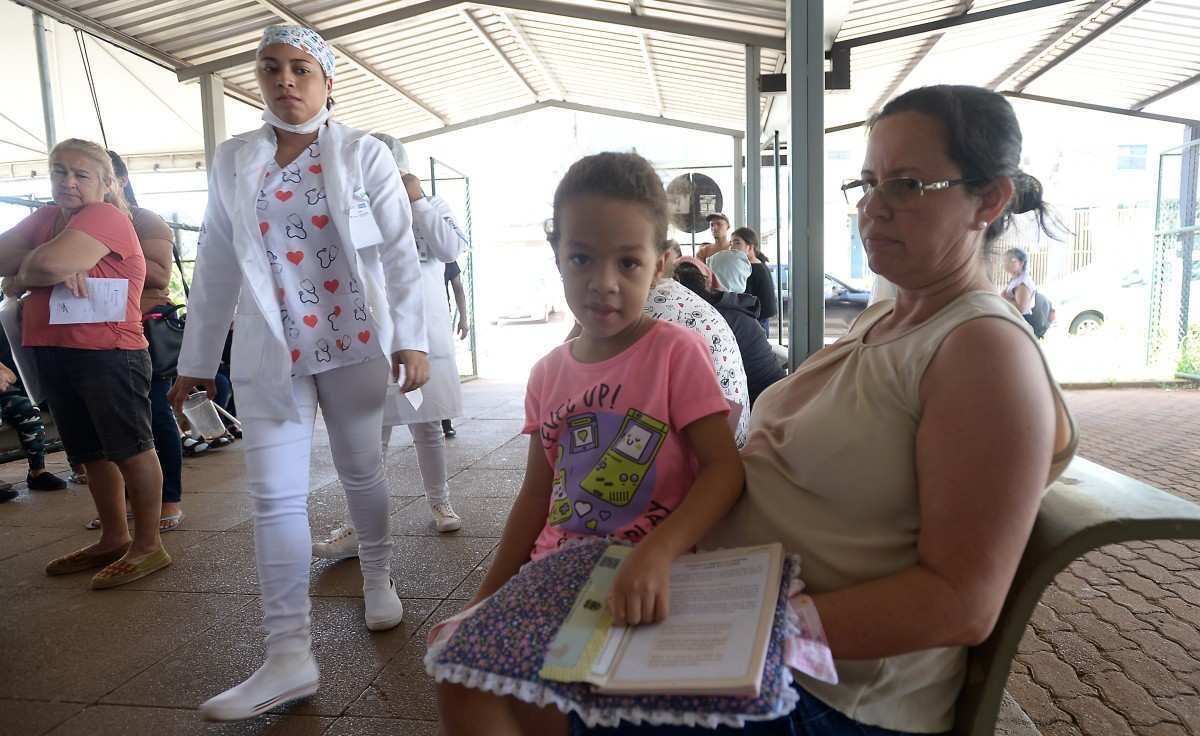  27/02/2024 Credito: Ed Alves/CB/DA.Press. Cidades. Surto de Dente no DF. Unidade Basica de Saude Nº 01 Samambaia Sul. Na foto, Denise de Oliviera (mãe) e filha Lorena. 