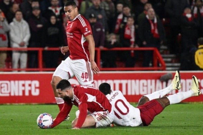 O brasileiro Felipe, de vermelho, luta pela bola com Rashford, do United. Ambos vão ao chão -  (crédito: Foto: Oli Scarff/ AFP via Getty Images)