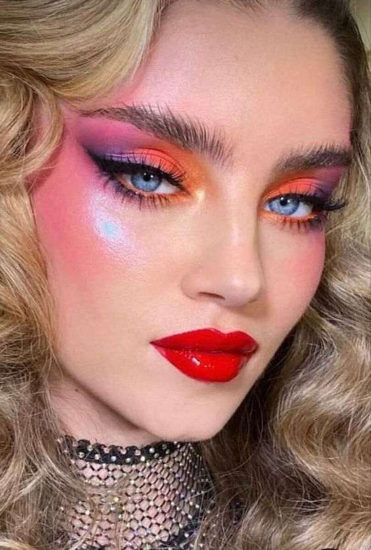 Exemplo de maquiagem clássica dos anos 80, com olhos coloridos e boca bem marcadas. 