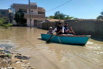 Moradores remam em um barco para atravessar uma rua inundada após fortes chuvas em Gwadar, na província do Baluchistão, em 2 de março de 2024
       -  (crédito:  AFP)