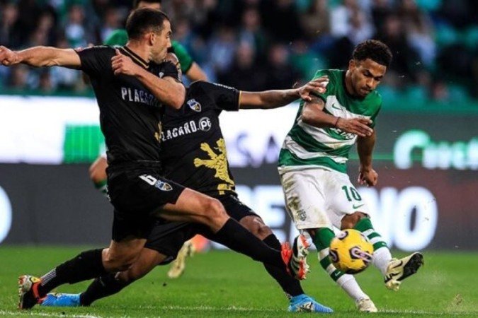 Marcus Edwards (de verde e branco) recebe a marcação de Talys Oliveira  e de Muscat, do Farense -  (crédito:  AFP via Getty Images)