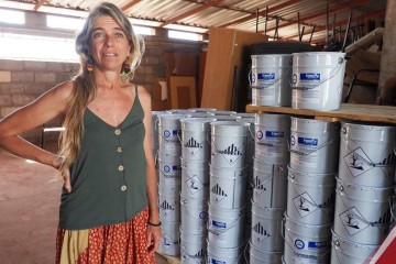 Lara Ferrero Gómez, líder da pesquisa, posa ao lado das latas de tinta, que poderão ser utilizadas também no combate à malária -  (crédito: Gabinete de Comunicação e Informação da Universidade Jean Piaget de Cabo Verde)