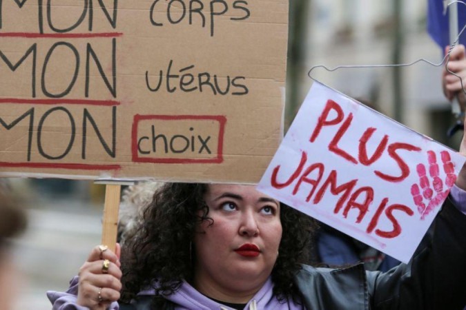 Manifestante segura cartazes que dizem 'Meu corpo, meu útero, minha escolha' e 'Nunca mais' durante protesto silencioso em apoio à revisão constitucional -  (crédito: Getty Images)