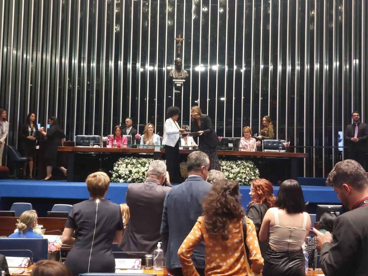 Professora Gina Vieira Ponte de Albuquerque recebe o Diploma Bertha Lutz das mãos da senadora Leila Barros