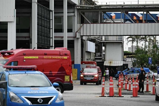 Pessoas são evacuadas do lado de fora do terminal de ônibus Novo Rio depois que um homem armado mantém passageiros como reféns no Rio de Janeiro -  (crédito: Pablo PORCIUNCULA / AFP)