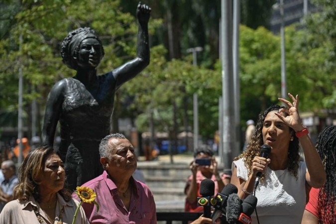 A ministra Anielle Franco, ao lado dos pais, discursa perto da estátua em homenagem à irmã, Marielle  -  (crédito: Mauro Pimentel/AFP)