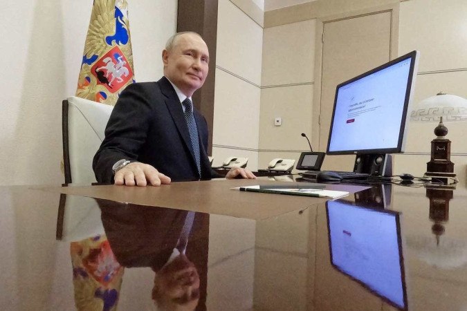 Nesta fotografia distribuída pela agência estatal russa Sputnik, o presidente russo, Vladimir Putin, vota online nas eleições presidenciais -  (crédito: Mikhail METZEL / POOL / AFP)