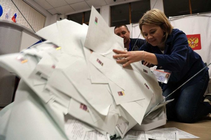  Members of a local electoral commission empty a ballot box at a polling station after polls closed in Russia's presidential election in Simferopol, Crimea, on March 17, 2024. (Photo by STRINGER / AFP)
       -  (crédito:  AFP)